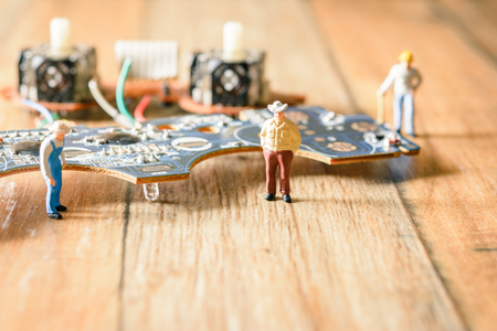 Electronic board with miniature figure worker man at repair and work. Selective focus.(Electronic circuit )の写真素材