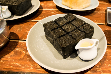 bread charcoal Served with condensed milk on the table in a cafe at nightの写真素材