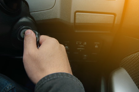 Hand on car key start a car