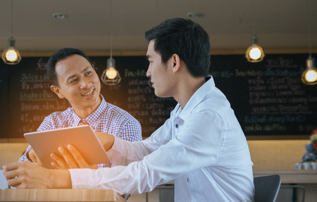 Concept Business talk Meeting Relex in coffee shop,table tablet and coffee on workplace in coffee shopの写真素材