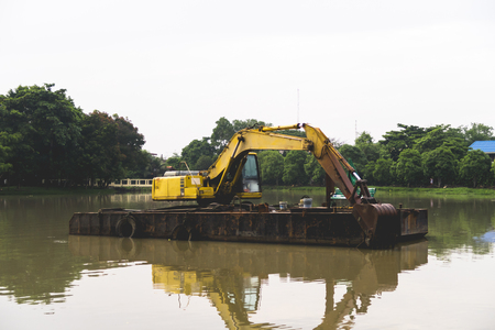 Yellow Excavator on lagoon