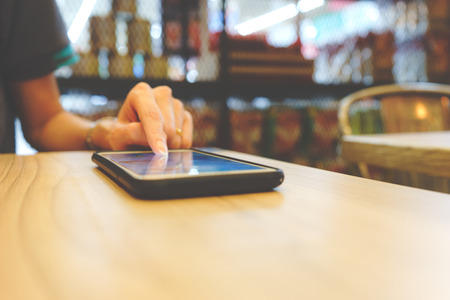 Hand on smartphone on the tableの写真素材