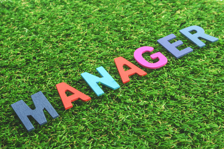 Colorful Wooden Alphabet Word manager on green grass backgroundの写真素材