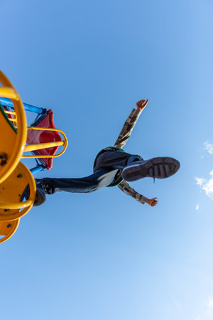 A shot of boy from below looking up at him flying in the blue sky.の写真素材