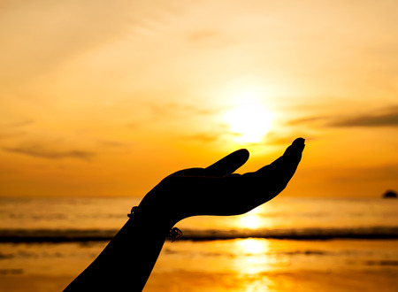 Hand with color of the sunset Beautiful nature Pathong beach Thailand