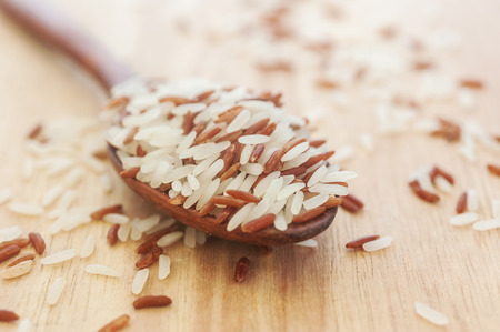 Rice berry, Brown rice in wooden spoon on wood, selective focusの写真素材