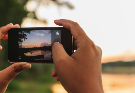 An image of shooting photographs with smartphone on blur backgroundの写真素材