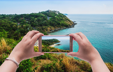 Image of shooting photographs with smartphone on seascape