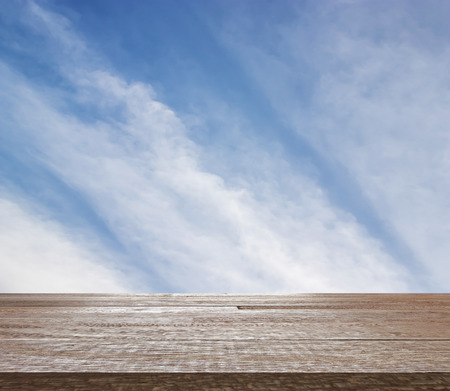 Wooden table top on blue sky with cloud, Blue sky and white cloud textue with pattern, Frame of blue sky and texture with pattern of white cloud for design, Can be use for display or montage you productの写真素材