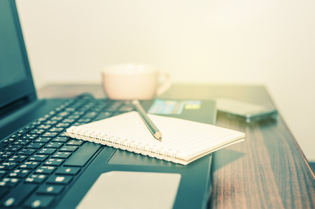 Office desk, Computer notebook with notepad and pencil and smart phone and cup of coffee on office...