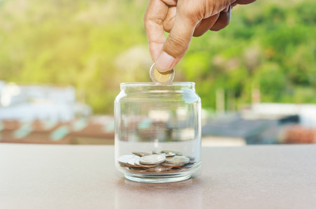 Close up of hand stacking silver coins on glass bottle, Business finance and money concept, Save...