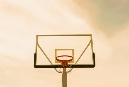 Basketball hoop on empty outdoor court with sky sunset backgroundの写真素材