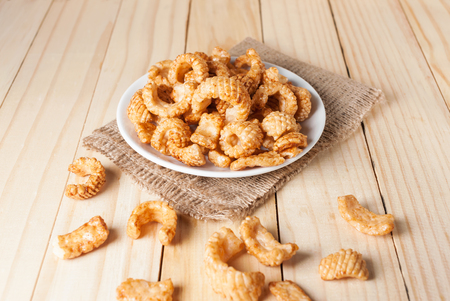 Junk food snack tase squid in white plate on wooden tableの写真素材