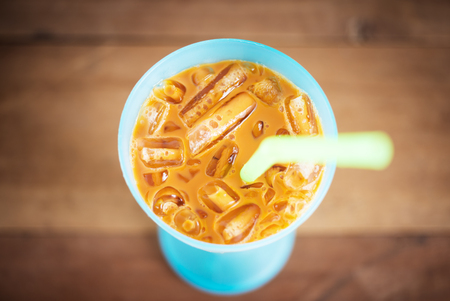 Ice tea with milk sweet drink on blurred vintage wooden table selective focusの写真素材