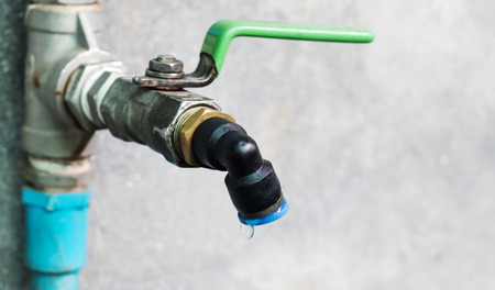 Wasting water - water drop from water tapの写真素材