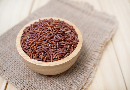 Rice berry in wooden bowl on wood background, Rice berry from asiaの写真素材