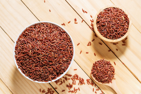 Rice berry in white bowl on wooden background, Rice berry from asiaの写真素材