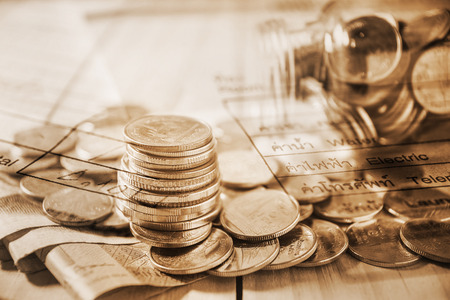 Double exposure rows of coins with utility bill and calculator and account banking for finance...
