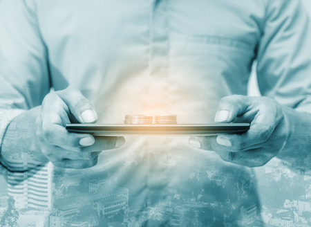 Double exposure online banking and internet banking and people networking account banking finance concept, Business man with laptop and coin money on business office tableの写真素材