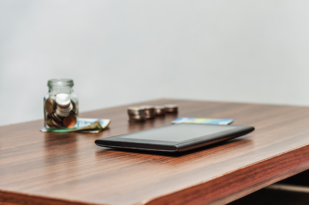 Online banking and internet banking and technology network concept, Saving money and account banking for finance business network concept, Laptop with smart phone mobile and coin money on business office tableの写真素材