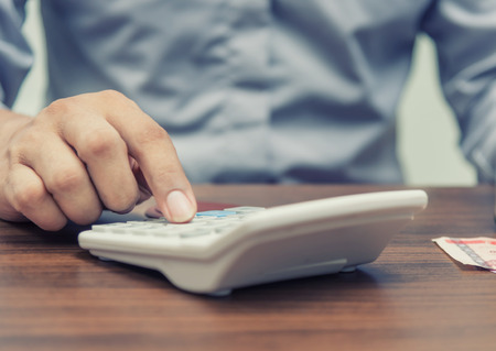 Accountant and investor concept, Saving money and account banking for finance business concept, Man with calculator on business office tableの写真素材