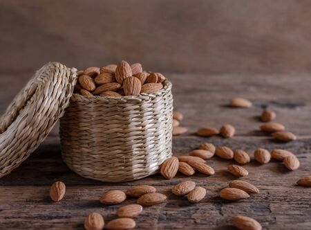 Almond in basket on blurred wooden table backgroundの写真素材