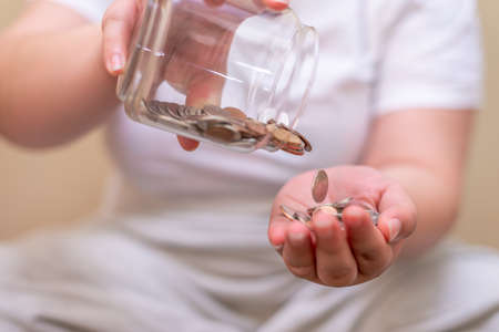 Save money and account banking for finance concept, Hand with coin on blurred backgroundの写真素材