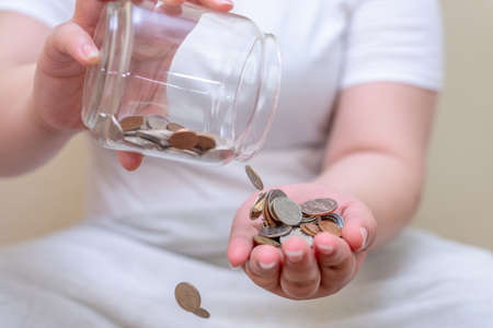 Save money and account banking for finance concept, Hand with coin bottle blurred backgroundの写真素材