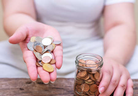 Save money and account banking for finance concept, Hand with coin on blurred background