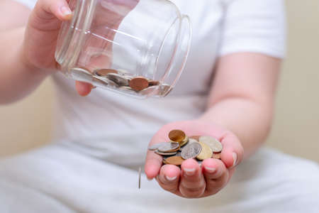Save money and account banking for finance concept, Hand with coin bottle blurred backgroundの写真素材