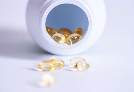 Pill spilling out of a bottle blurred background, Medicine capsule for health, Vitamin spilling out from bottle, Macroの写真素材