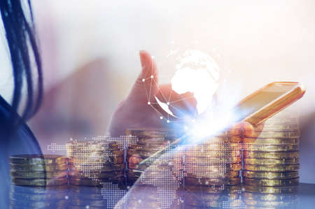 Double exposure online banking and internet banking and people networking account banking finance concept, Women with smartphone and coin money and cityscapeの写真素材