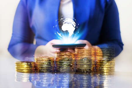 Double exposure online banking and internet banking and people networking account banking finance concept, Business women with laptop, phone, cellphone, tablet, smartphone mobile, and coin money on business office tableの写真素材