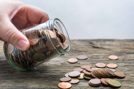 Save money and account banking for finance concept, Hand with coin on blurred backgroundの写真素材