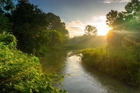 View of Colorful dramatic sky sunset or sunrise with clouds background on Water River in Forest, Sky with cloud in nature and travel concept.の写真素材