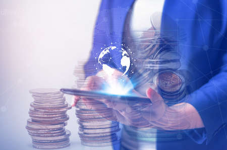 Double exposure online banking and internet banking and people networking account banking finance concept, Young women with laptop, phone, cellphone, tablet, smartphone mobile, and coin money on blurred backgroundの写真素材
