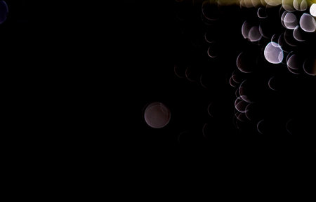 Light abstract dark bokeh christmas circle color glitter blurred black backgroundの写真素材