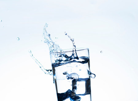 The image of pouring drinking water, into a glass, that makes one feel refreshed on blurred white...