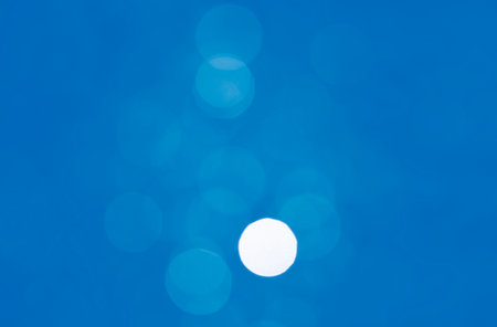 Light abstract blue bokeh christmas circle color glitter blurred black backgroundの写真素材
