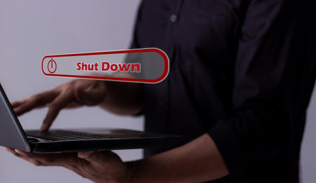 Young man hand touching laptop Shut Down button press power OFF