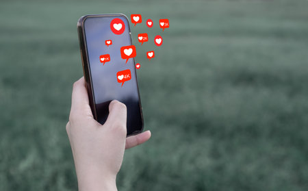 Young women hand Holding, Using smart phone mobile with Love and Comment Icon, Social Media, on soft...