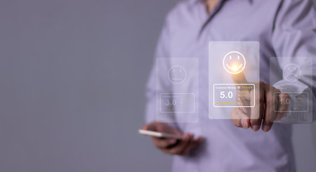 Customer Review, Young Man with smartphone mobile hand touch emoji five star to review and give 5 stars with very good results in service, Good review 5 star rating choice feedbackの写真素材