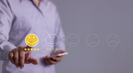 Customer Review, Young Man with smartphone mobile hand touch emoji five star to review and give 5 stars with very good results in service, Good review 5 star rating choice feedbackの写真素材