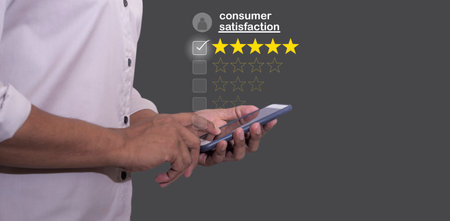 Consume Satisfaction, Young Man hand holding smartphone mobile with five star to review and give 5 stars with very good results in service, Good review 5 star rating choice feedbackの写真素材