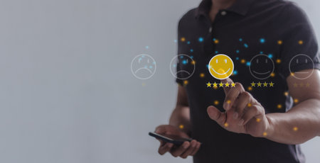 Review Excellence, Young Man with Smart Phone hand touching emoji and five star to review and give 5 stars with very good results in service, Good review 5 star rating choice feedbackの写真素材