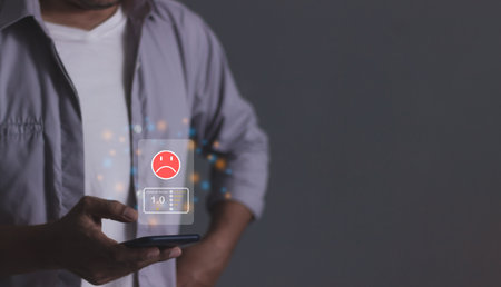 Customer Review, Young man hand holding smartphone to review and gives 1 star, with poor service results, Bad review Rated just 1 star Feedback optionsの写真素材