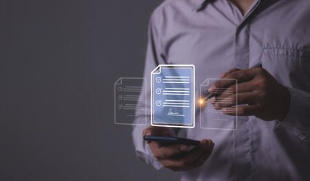 Young man with smartphone mobile hand using a pen touching to sign a Online Business Contract, Electronic signature, Contract signing, Digital documents, Future smart contractの写真素材
