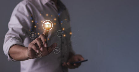 Young man with smartphone mobile hand to visualize bank money growth, The phone screen displays banking showing increasing investment and savings trends, Along with an increased account balanceの写真素材