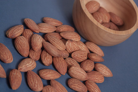 Almonds rest on a simple piece of paper, highlighting their natural texture in a clean minimal...