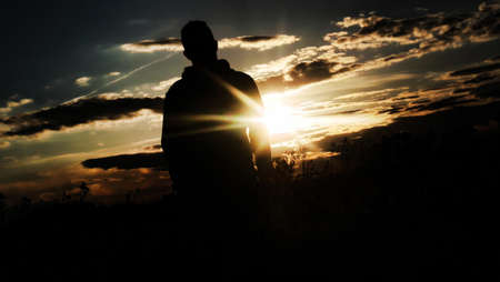 backlit boy on a summer afternoon in the fieldの写真素材